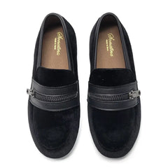 Pair of black loafers with a zipper detail on a white background